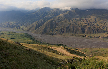 A view of a valley with a mountain in the background. Photo by Alexey Elfimov, Unsplash.